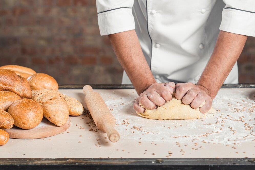 baker-kneading-dough-counter_23-2147883571